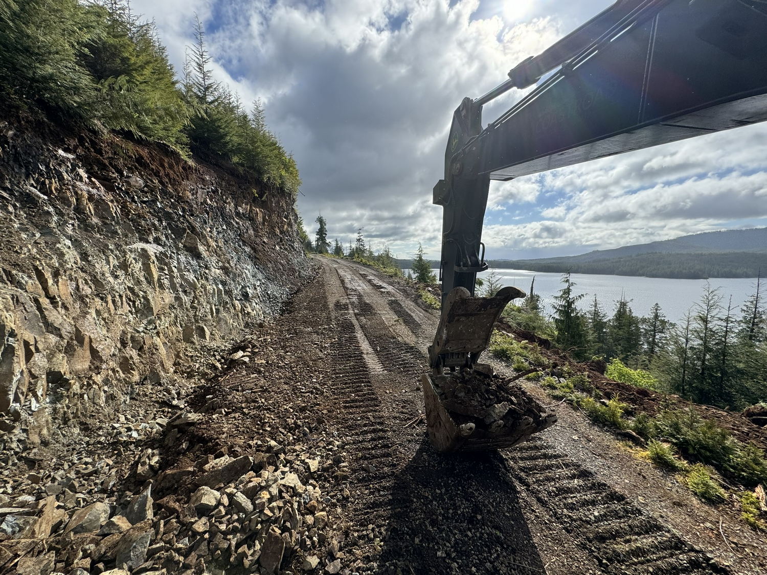 coast-roads-constrution-roads-01 Excavator on rocky, unpaved road