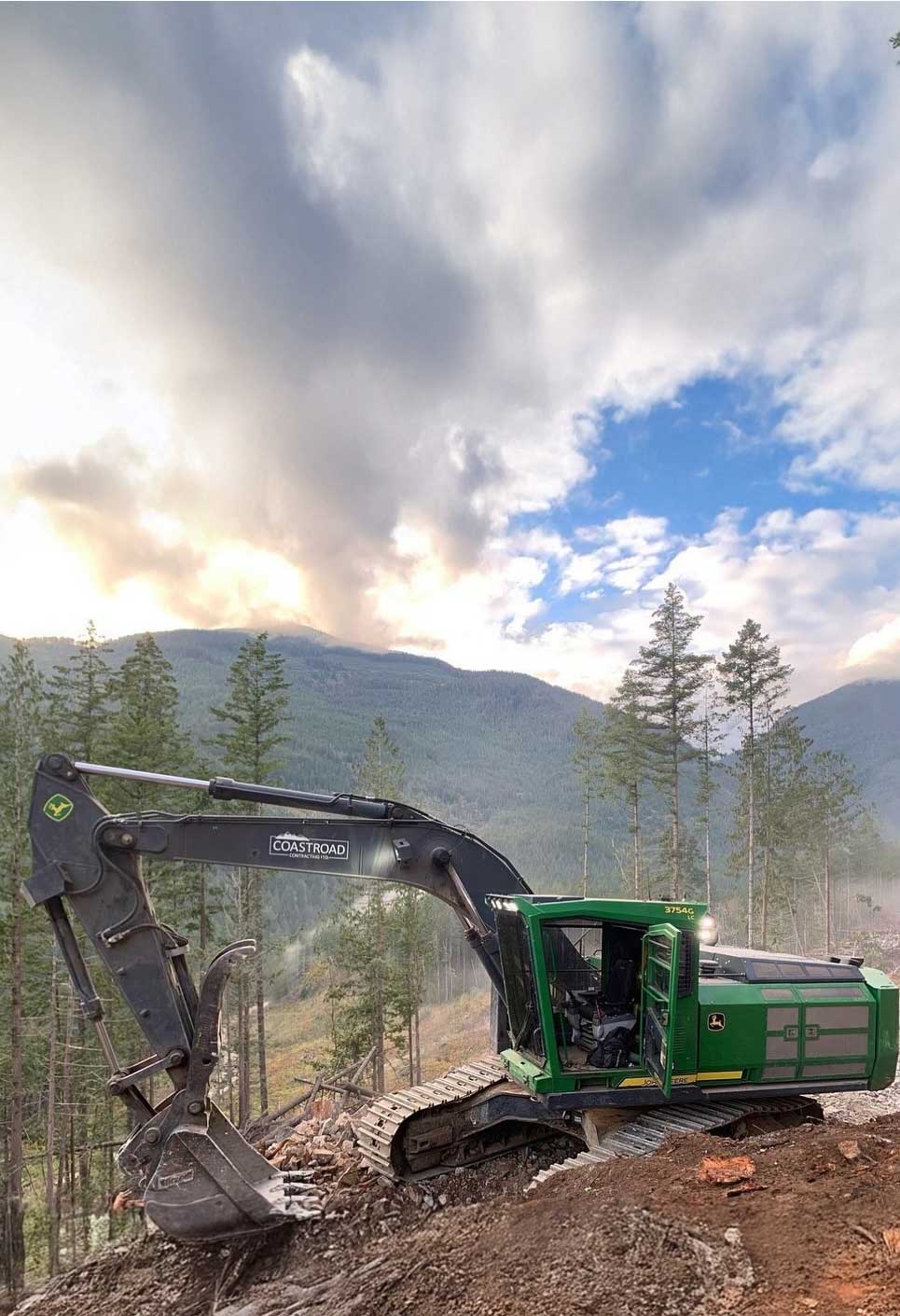 equipment-john-deer-roadbuilder Excavator working in mountainous terrain.